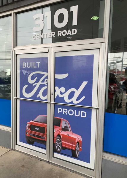 "Built Ford Proud" door view-through decals at Ford dealership