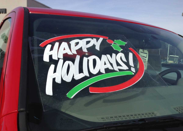 Hand-painted windshield sign says "Happy Holidays!"