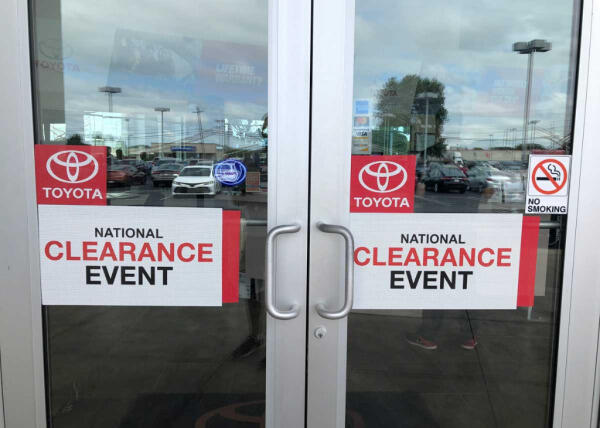 Custom glass door banner decals advertising national clearance event at Toyota dealership